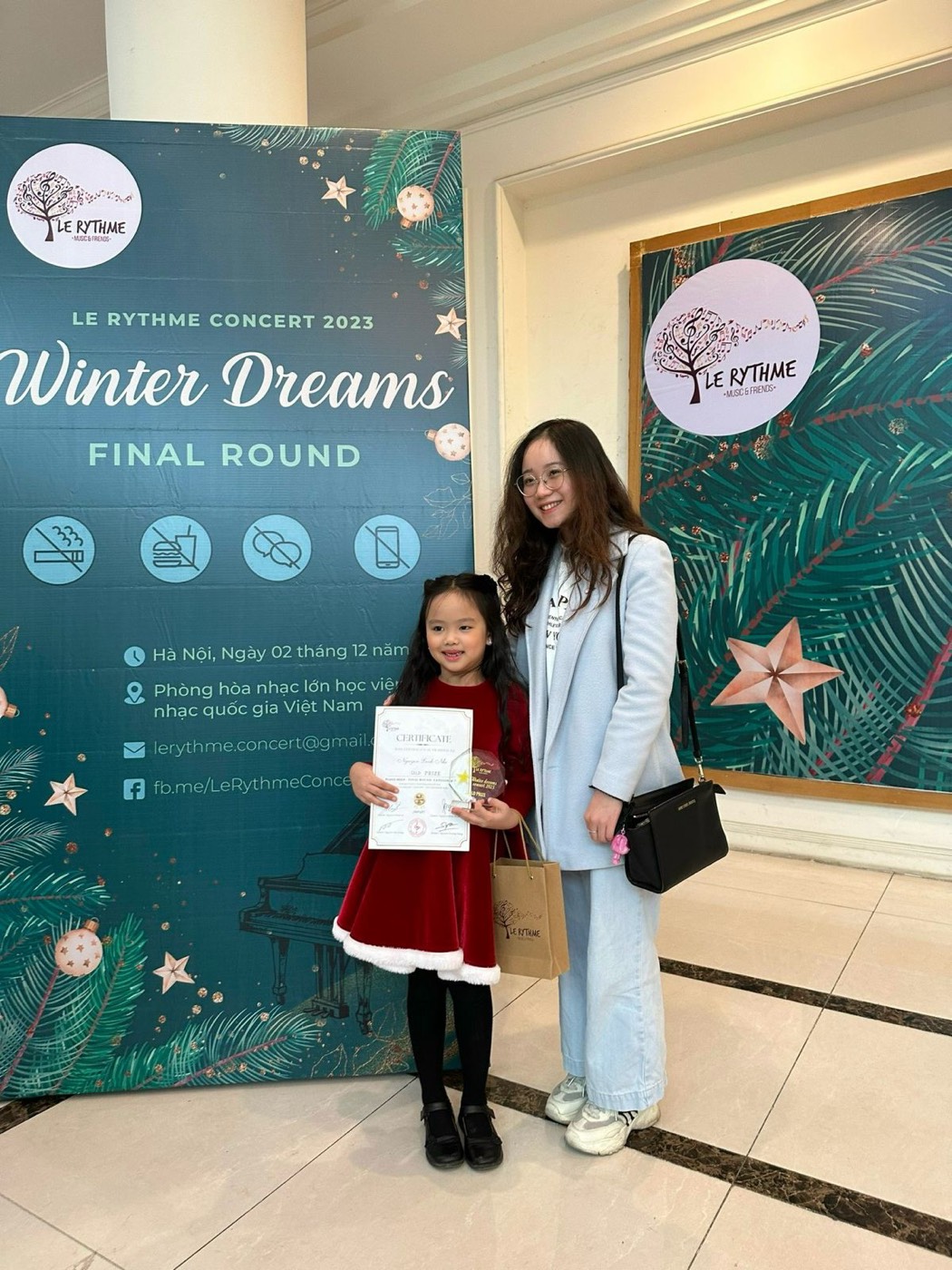 Ms Van with her young student, who is holding her Gold Prize certificate at the Le Rythme Winter Dreams concert 2023